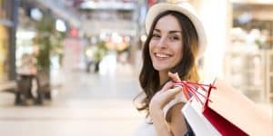 Smiling female holding shopping bags on her back